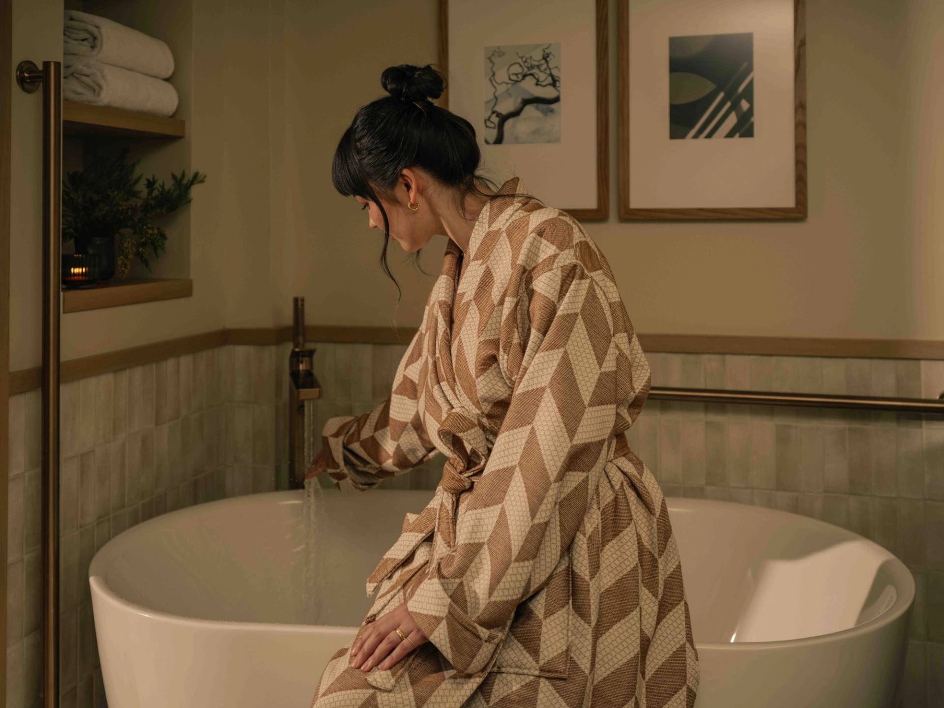 Spa suite with a freestanding soaking tub, soft lighting, wall art, and plush towels at Rimrock Banff.