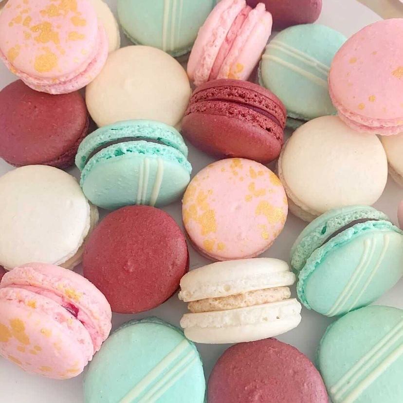 Assorted pastel macarons in pink, blue, cream, and red shades