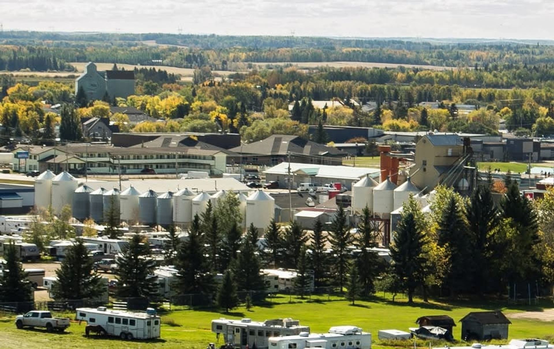 Small industrial town with grain silos, RV park and surrounding forested farmland.