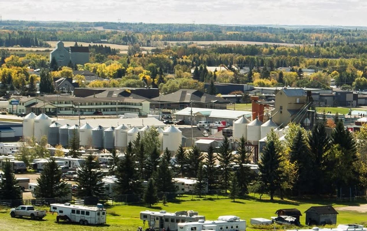 Small industrial town with grain silos, RV park and surrounding forested farmland.