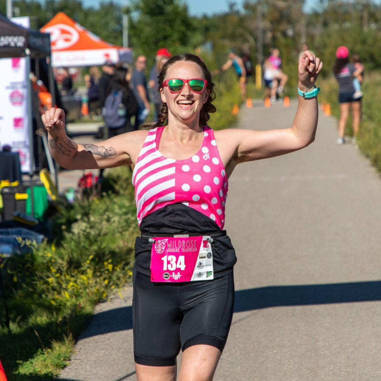 A runner with her arms in the air running.