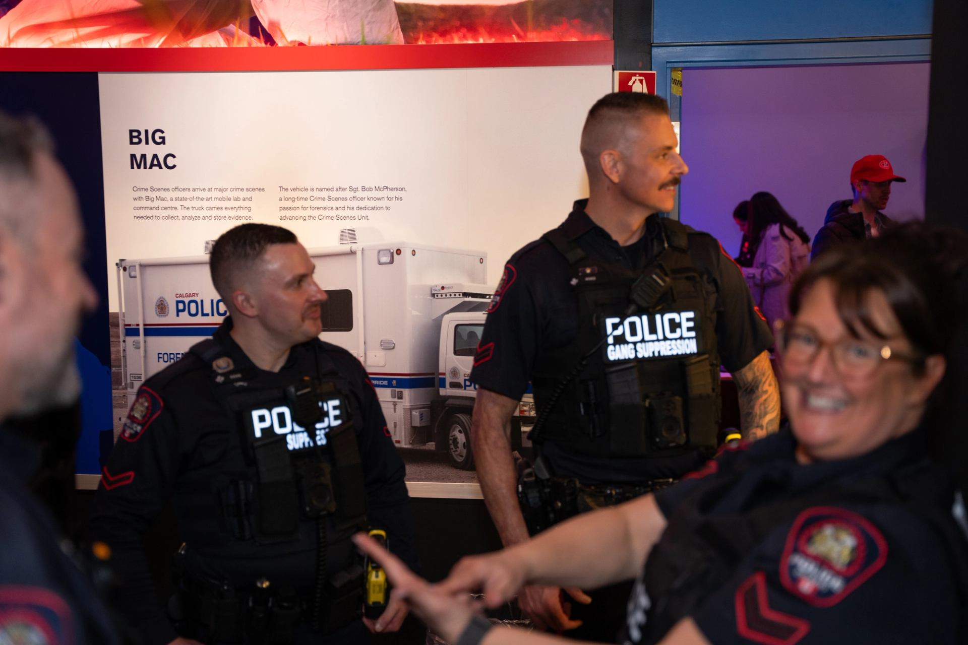 Police officers gather beside a Calgary Police exhibit about a forensic services vehicle.