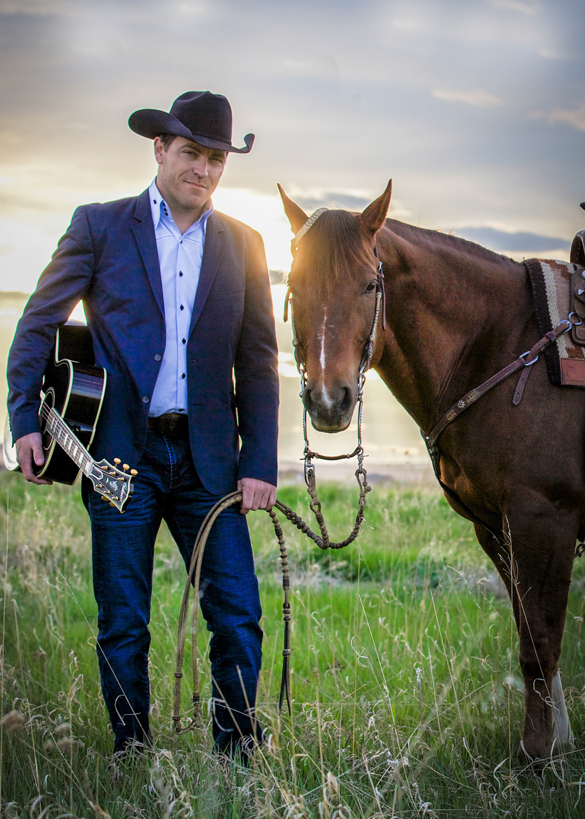 George Canyon holding his guitar stood by a horse