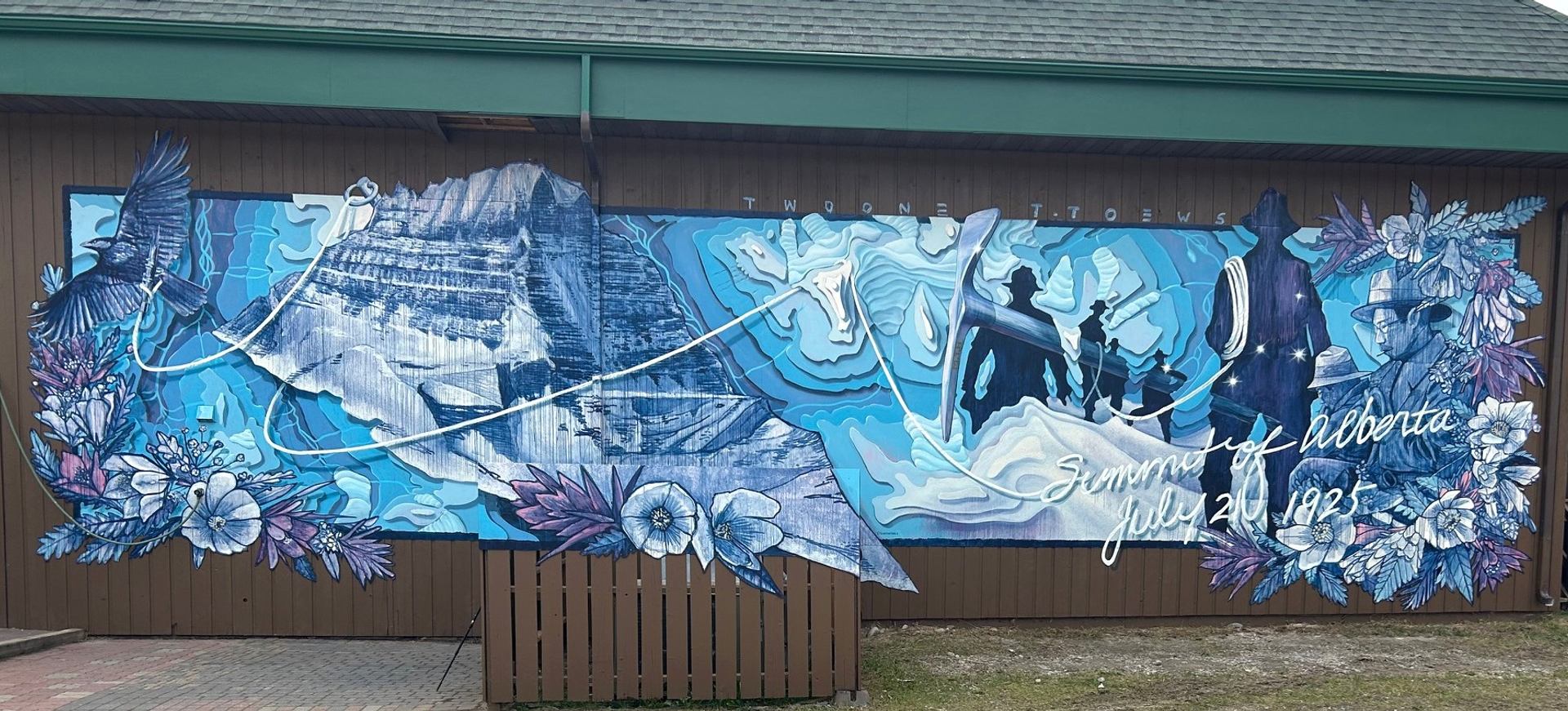 Colourful outdoor mural showing mountain landscape, flying bird, flowers and historic figures in Alberta.