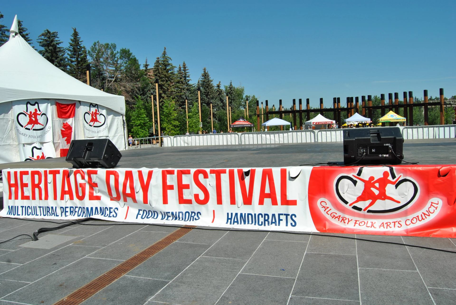 Outdoor stage with Heritage Day Festival banner and tents in the background.