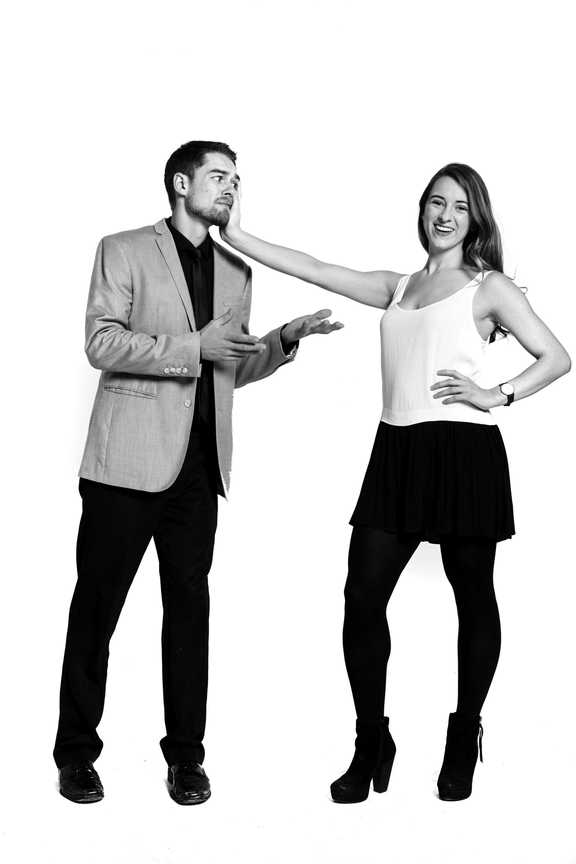 A man and woman stood up. The lady has her hand on the mans face.