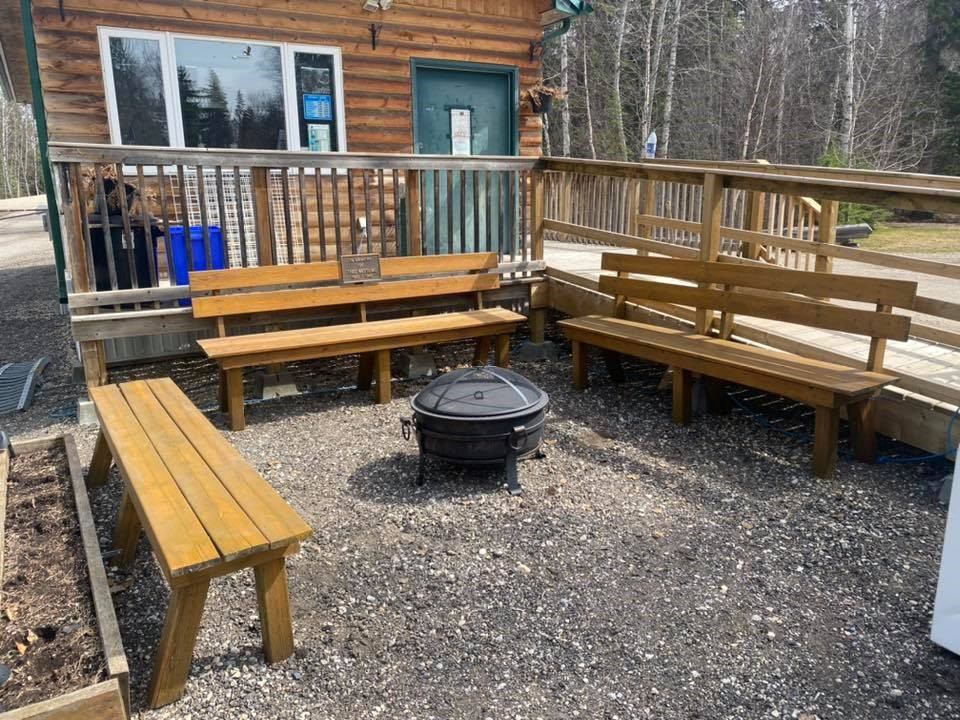 Gravel fire pit area with wooden bench seating