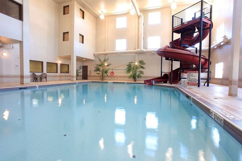 Indoor pool with a red spiral waterslide and seating area.
