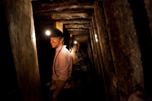 Couple wearing headlamps on a group tour of the Atlas Coal Mine National Historic Site.