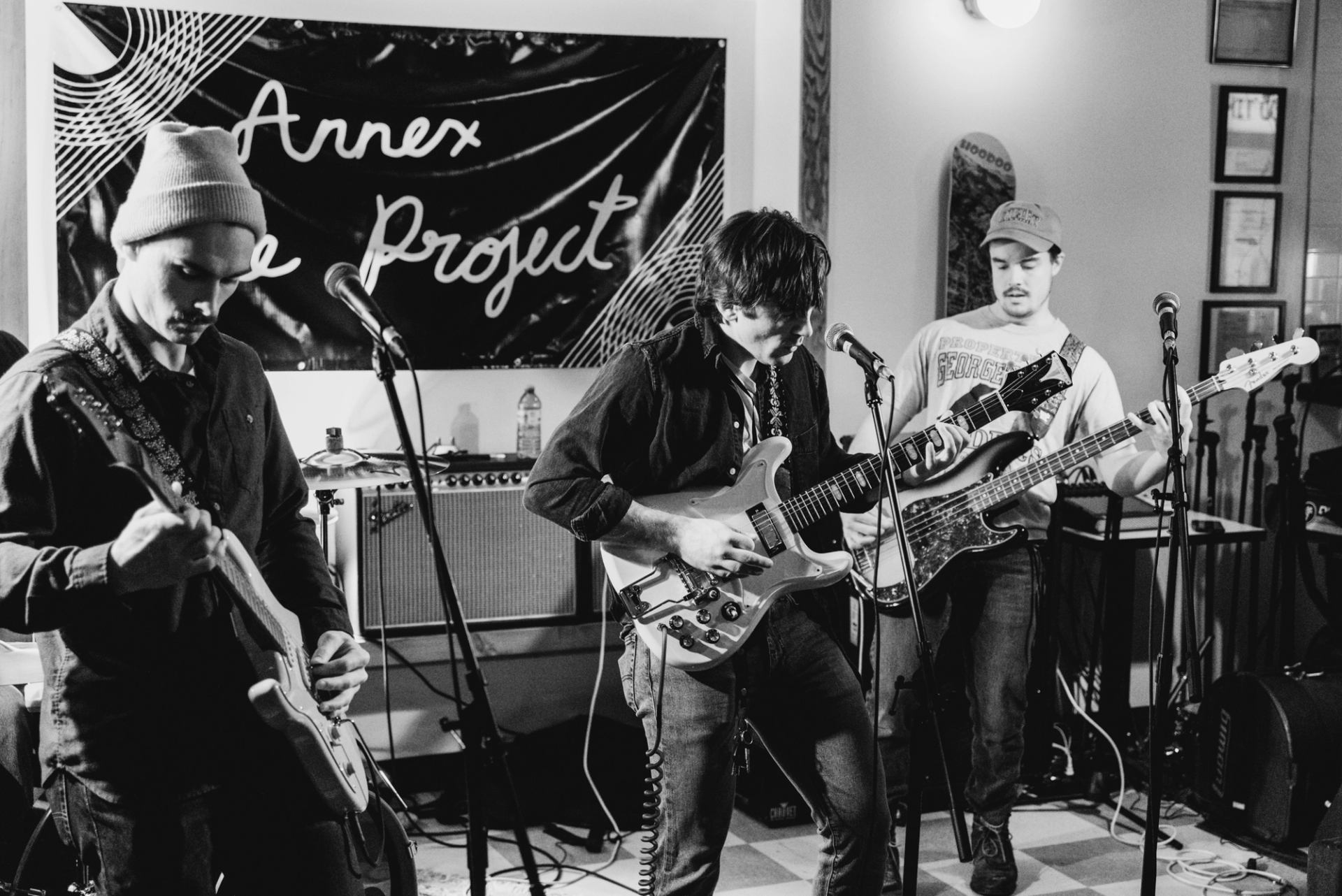 Group of musicians playing guitars and singing on stage during a live band set
