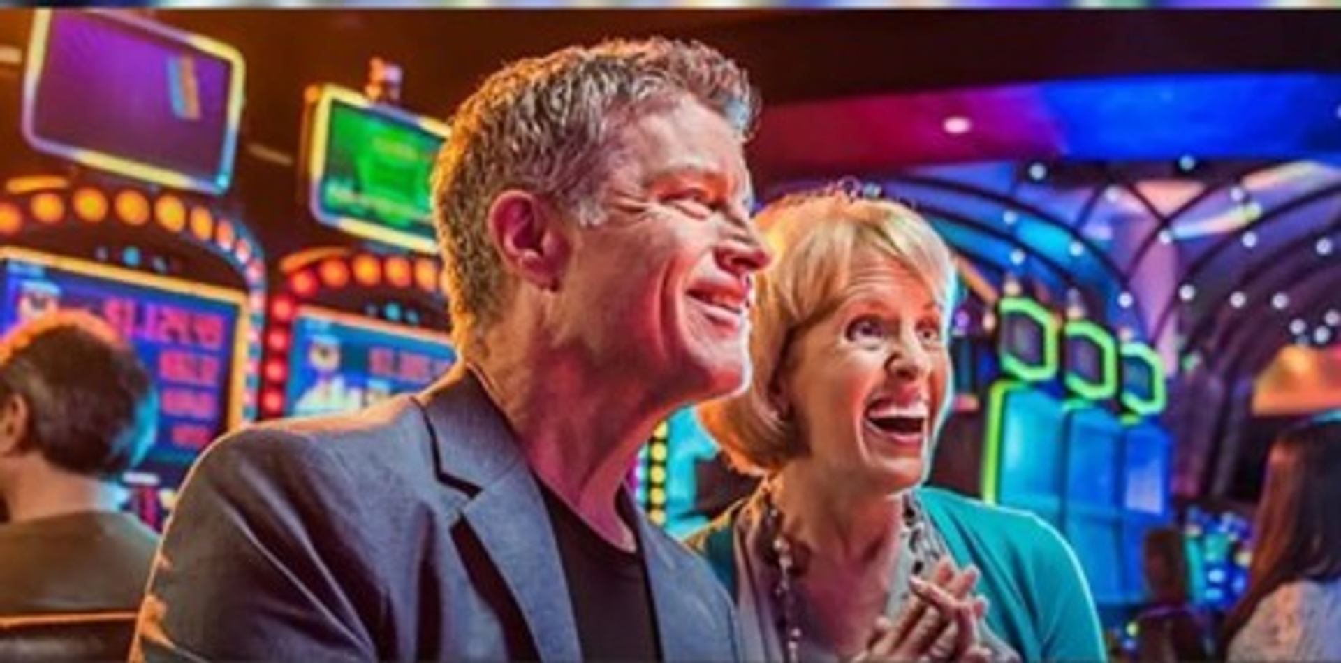 Excited man and woman laughing in a casino.