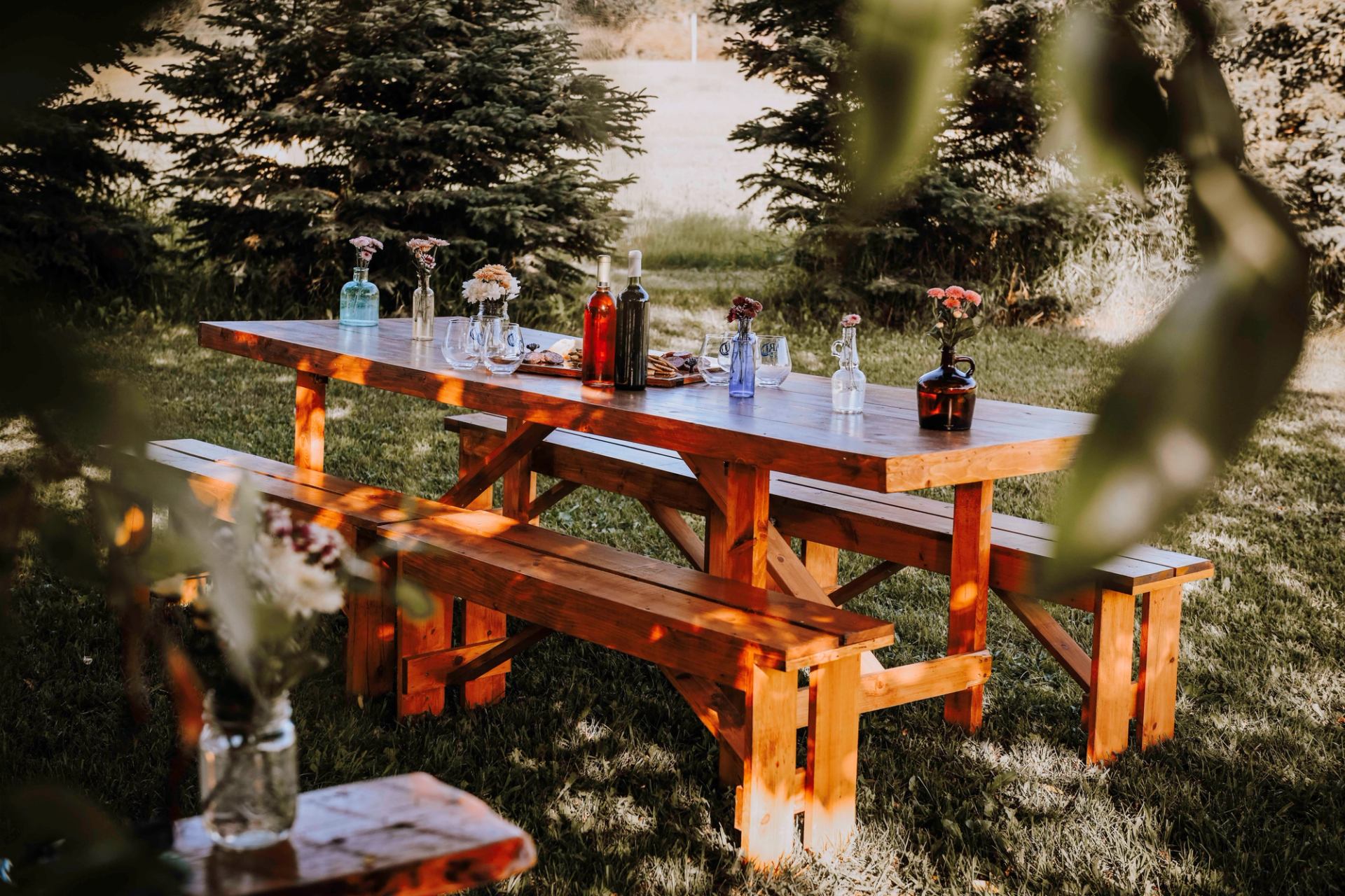 A picnic table sat for guest with beverages and a charcuterie .