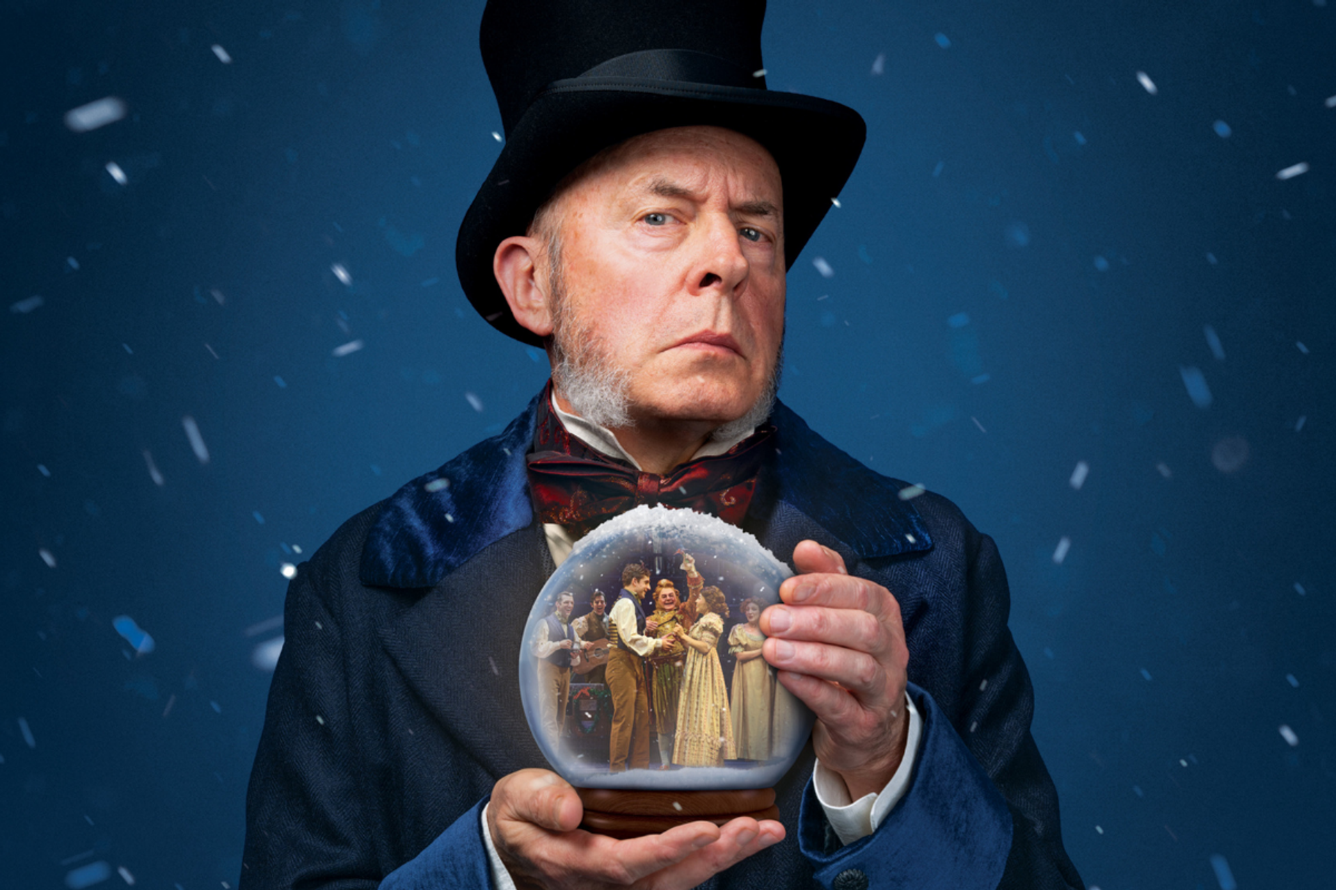 Older person in Victorian costume holds snow globe showing people in festive clothing.