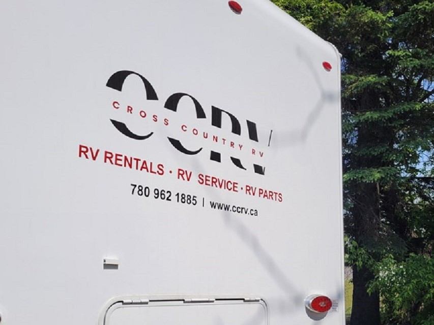 RV rental sign on a white truck with Cross Country RV text and logo.