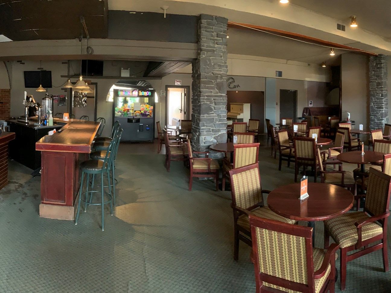 Casual dining area with wooden tables and bar seating at Smoky Lake Inn.