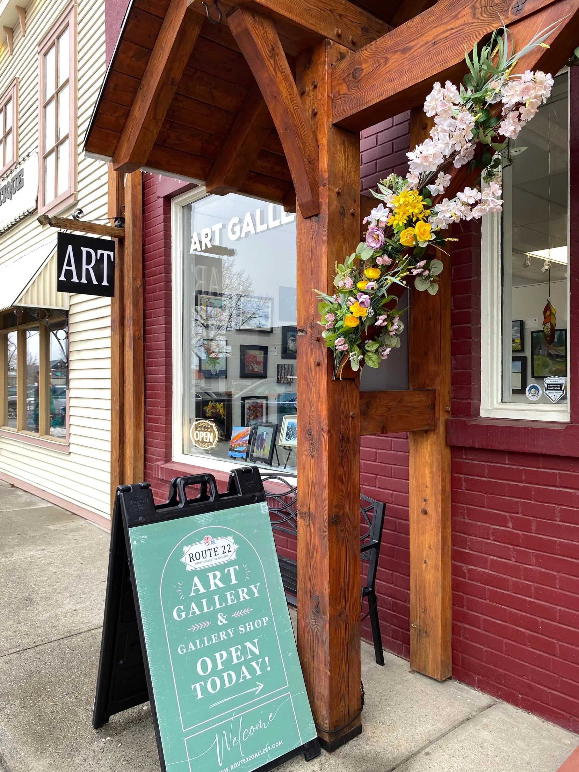 Route 22 Art Gallery entrance with floral display and open sign.