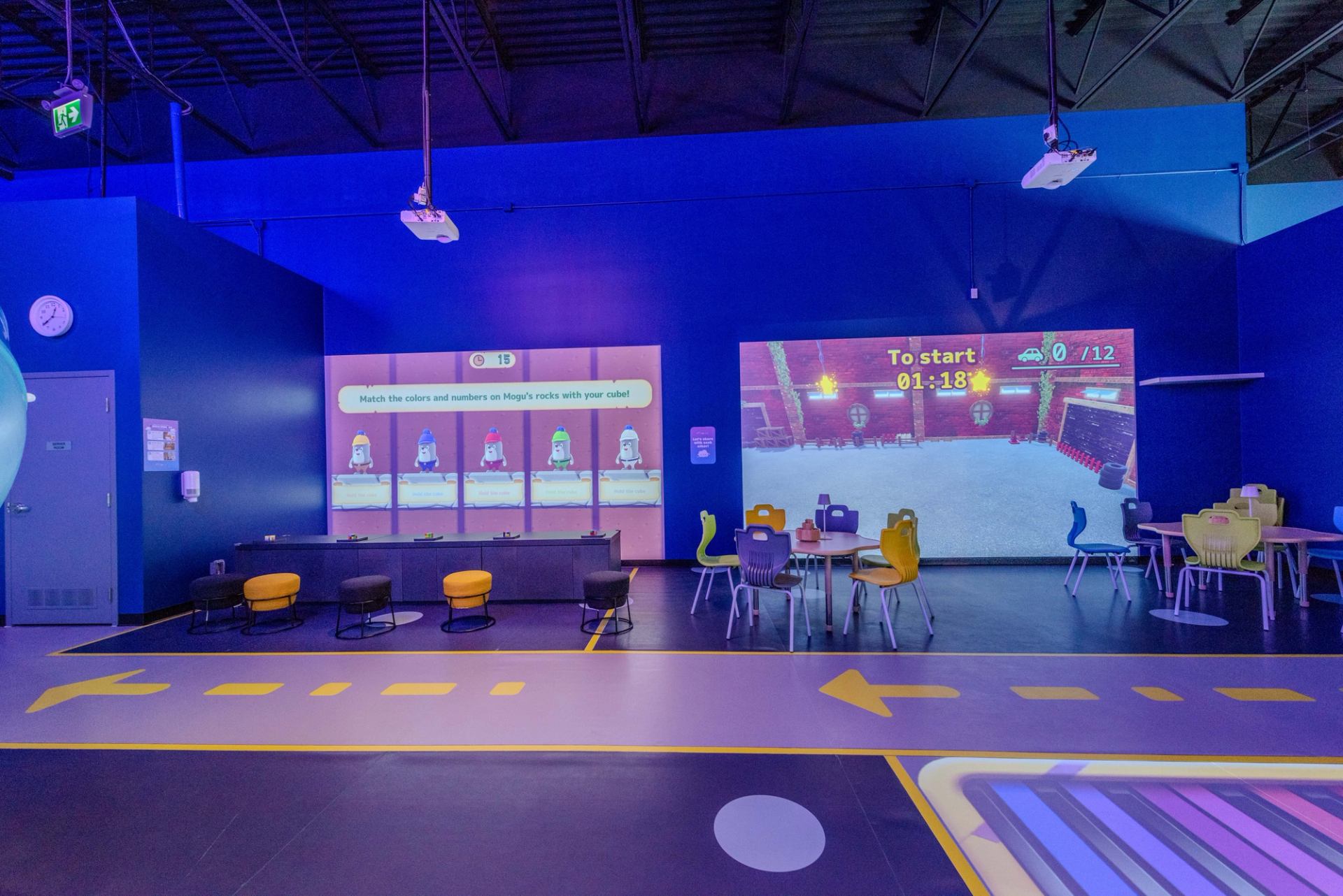 Interactive gaming area with large projection screens and colorful chairs at Cloud Land.