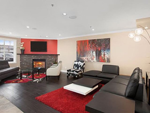Hotel lounge with sectional sofas, fireplace, wall art, and red rug.