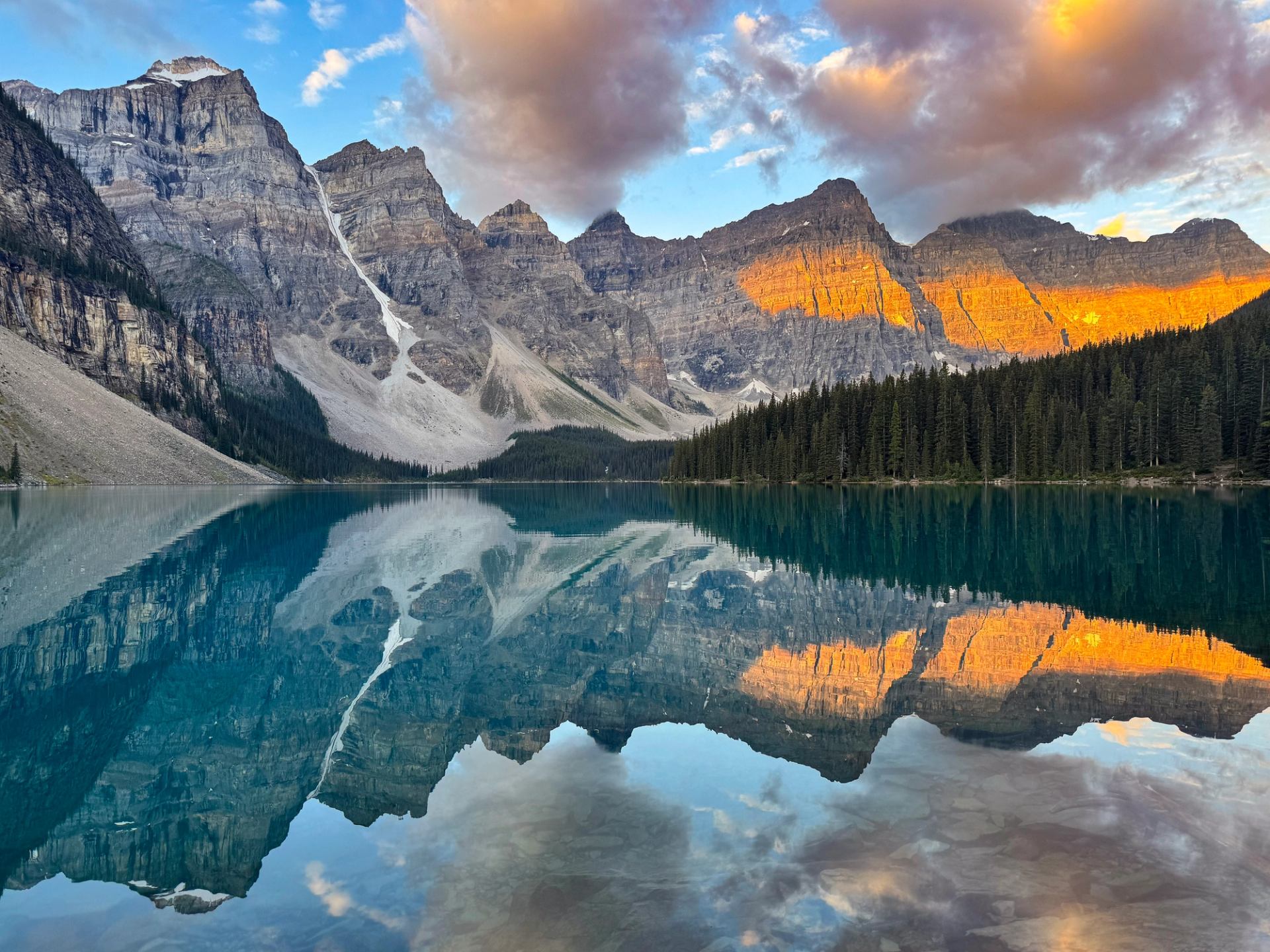 Sunrise golden light reflecting off mountains in Moraine Lake.