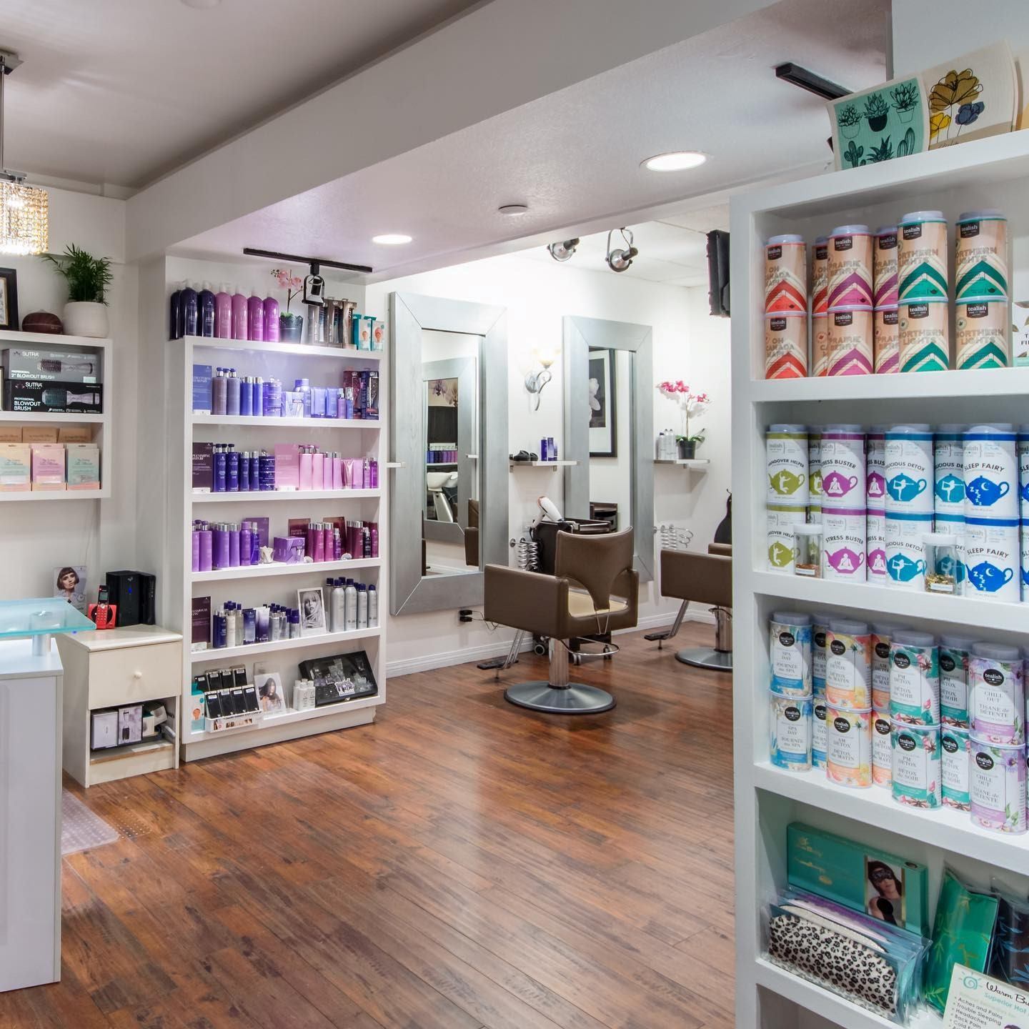 Day spa reception area with shelves of products and two barber-style chairs.
