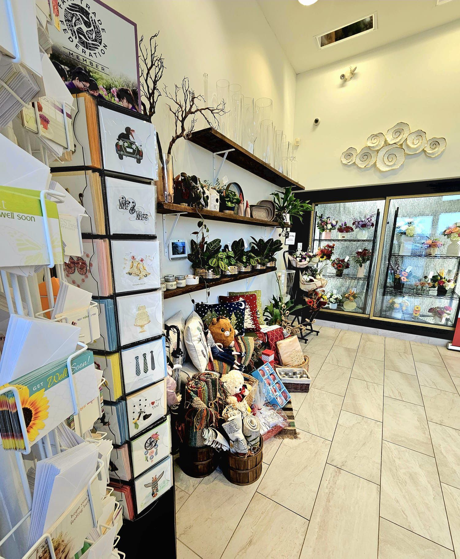 Store interior with cards, gifts, and floral arrangements in coolers.