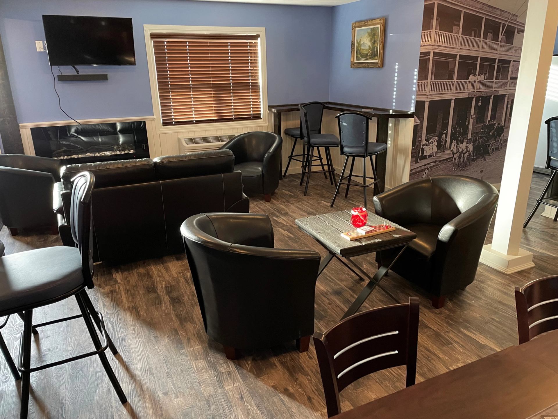 Travelodge lounge with leather chairs, tables, and wall art.