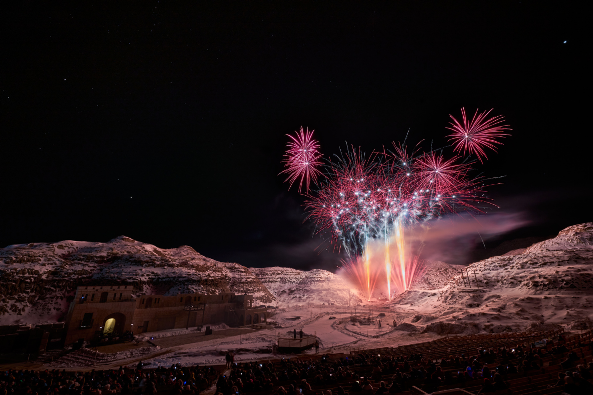 Pink fireworks explode above the hills of the Badlands Amphitheatre 