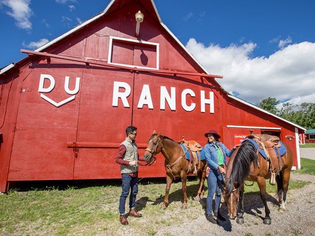 Guests standing in front of a red barn before horseback riding at Centre Peak High Country Adventures in the Crowsnest Pass.