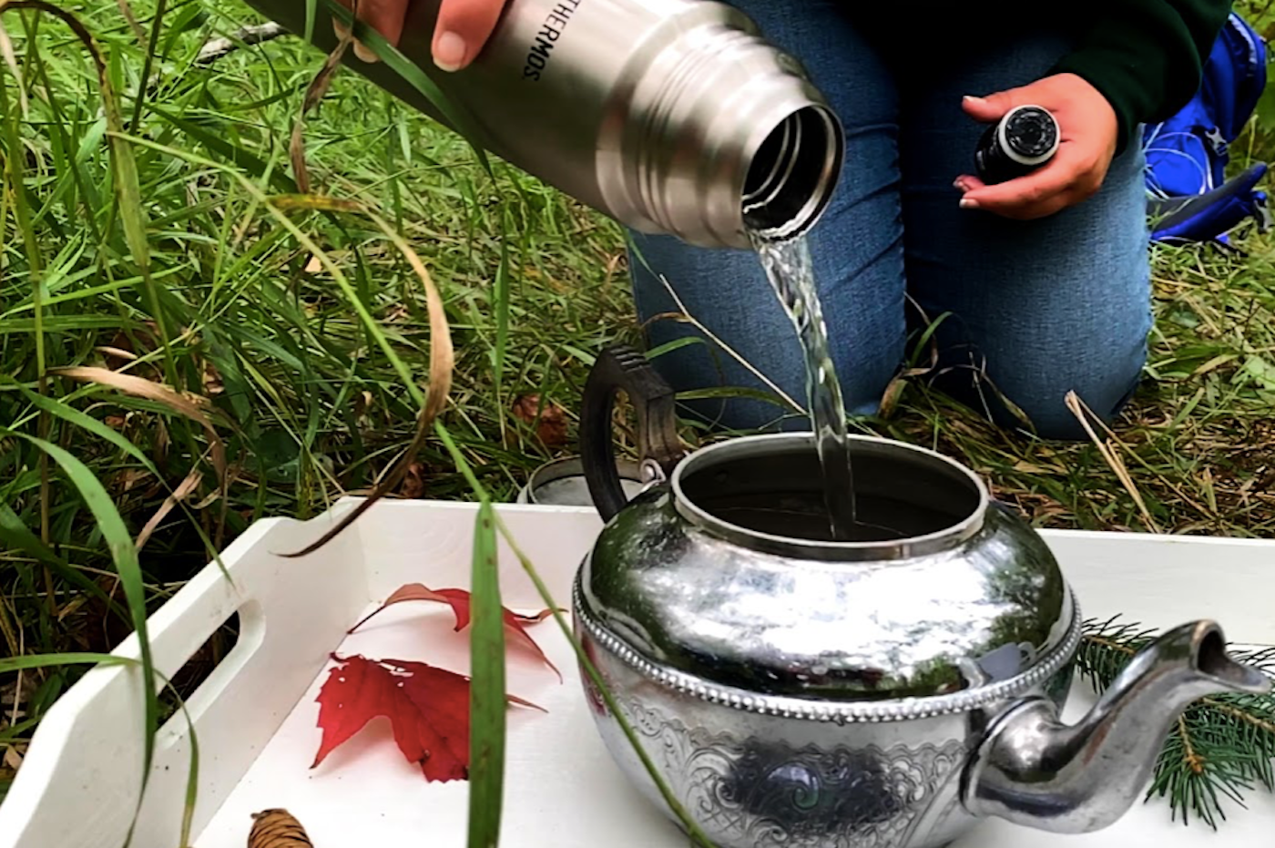 A person pouring hot water into a kettle to have a boil up