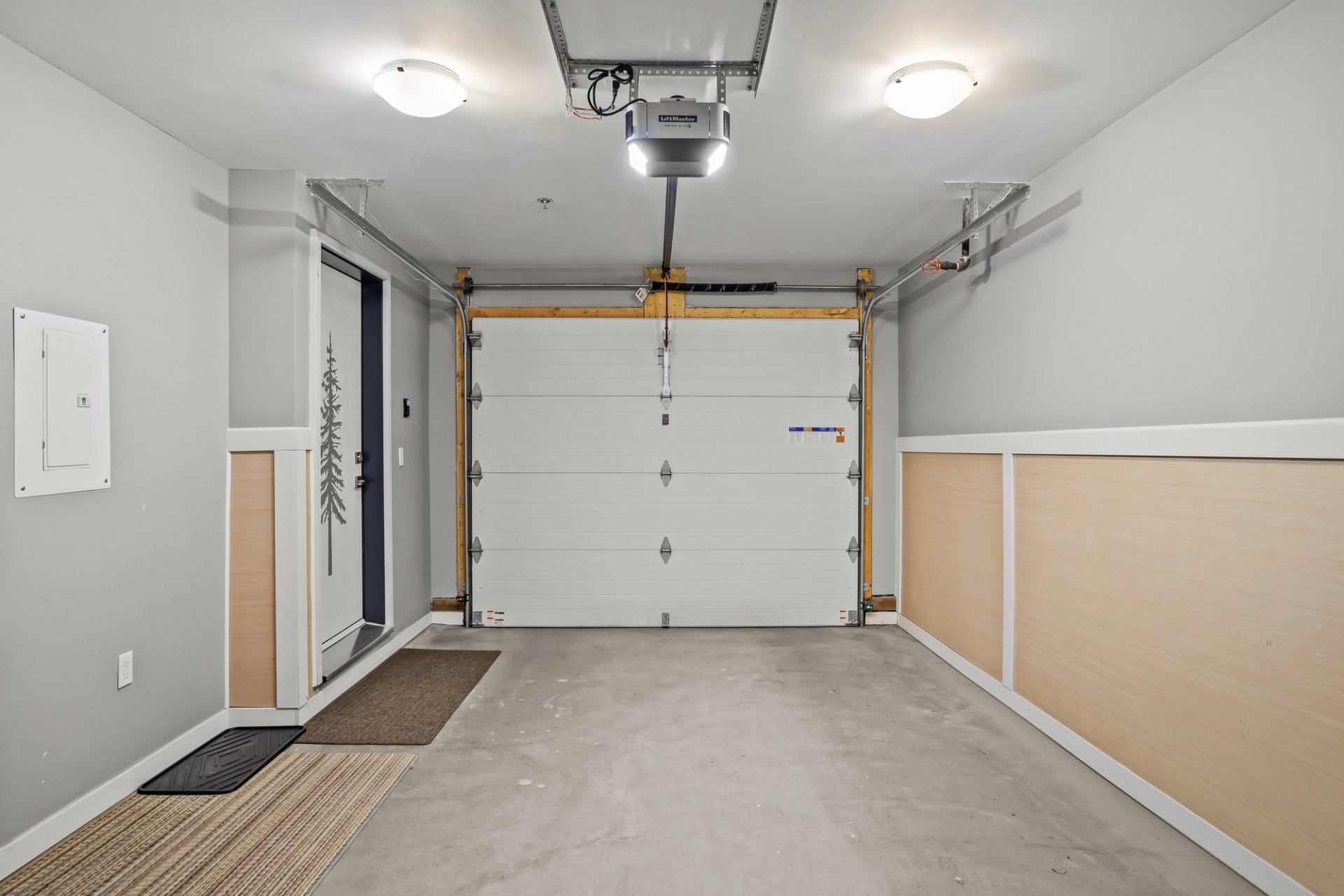Garage interior with closed overhead door, concrete floor and adjacent entry door.