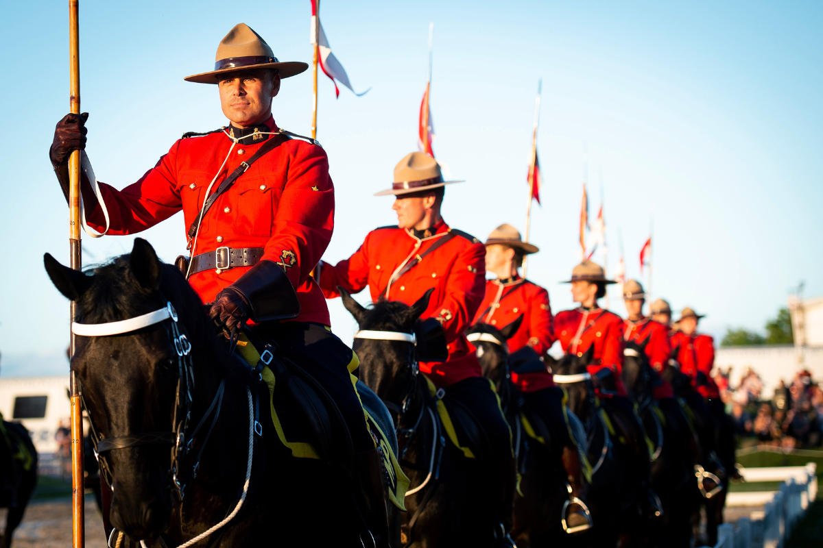 Equestrian riders in red uniforms mounted on black horses during RCMP Musical Ride.