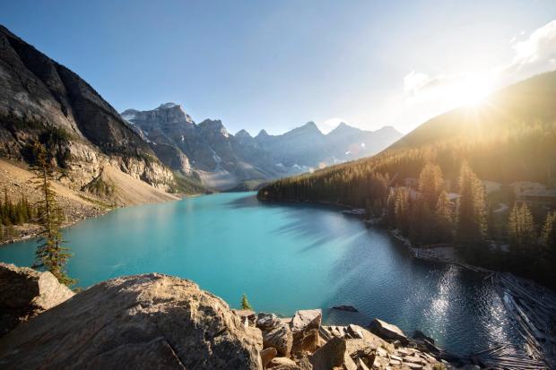 An elevated view of a beautiful Moraine Lake as the sun rises in Banff National Park.