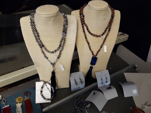 Jewellery display with beaded necklaces on busts, earrings and bracelets on stands.