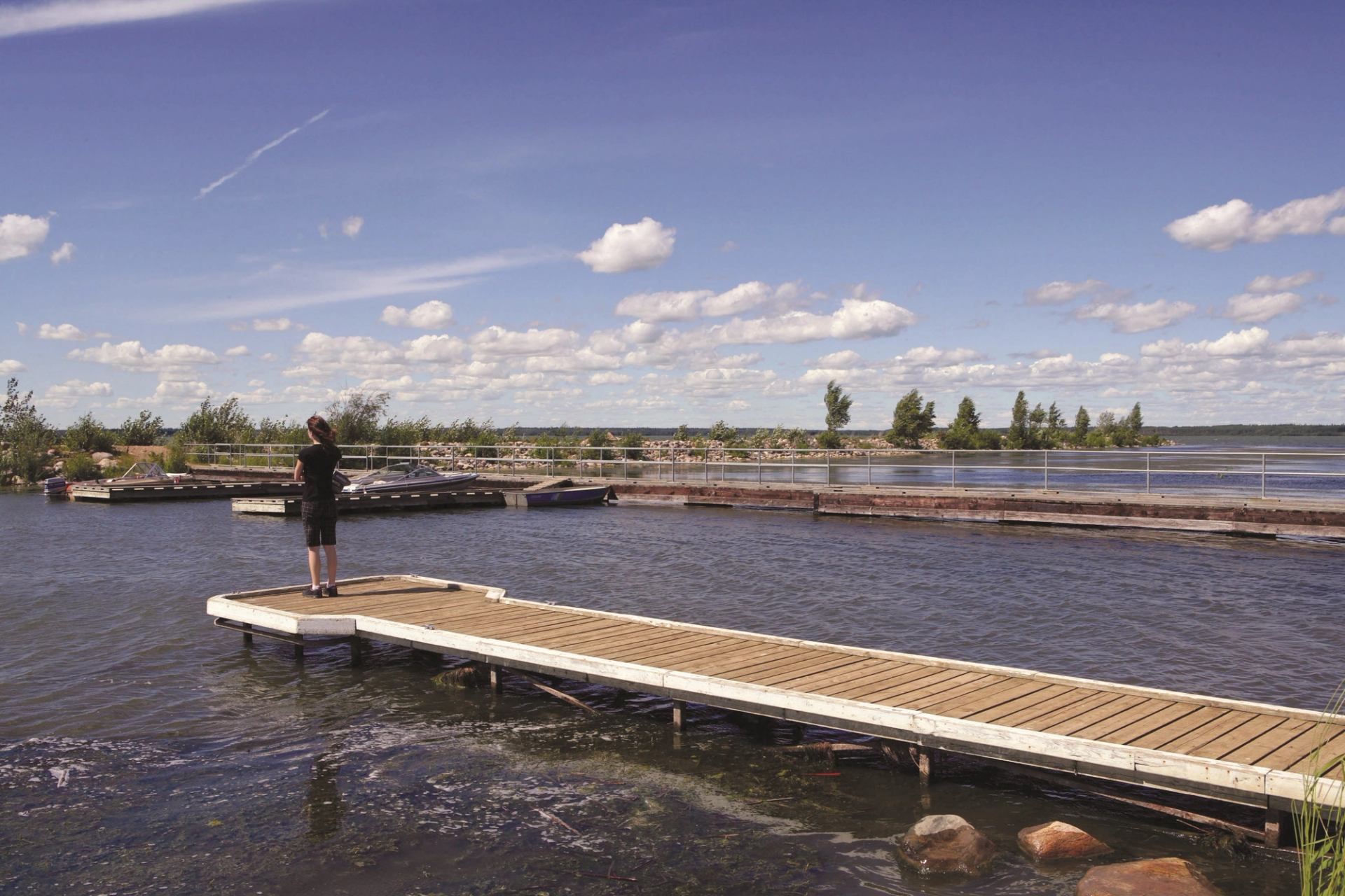 A person fishing from a pier at Winagami Lake Provincial Park.