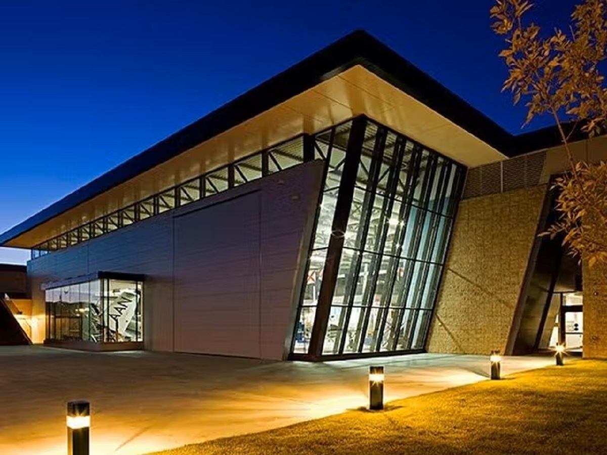 Modern museum building with glass windows lit up at dusk.