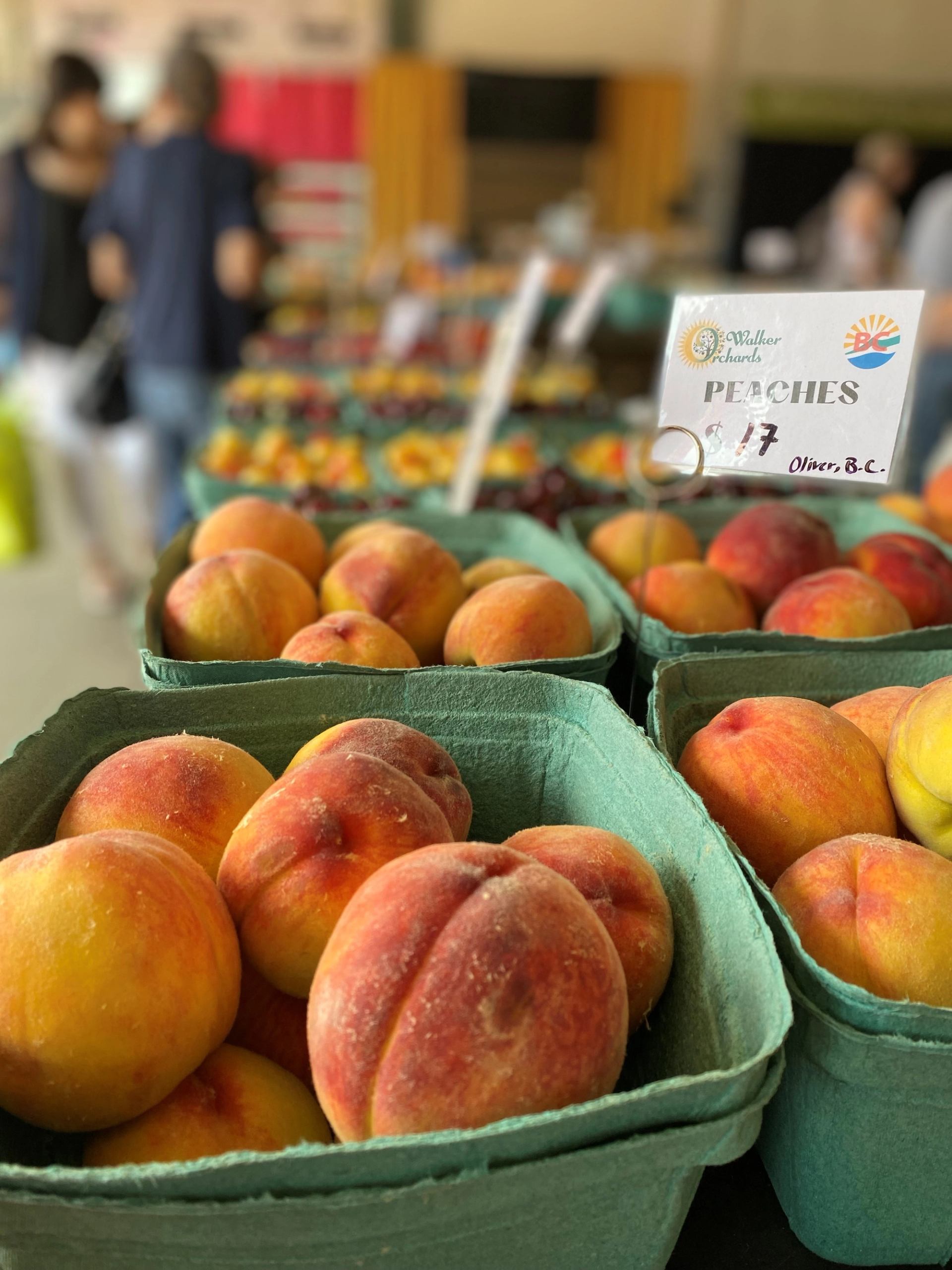 Close-up of ripe peaches in green baskets at market