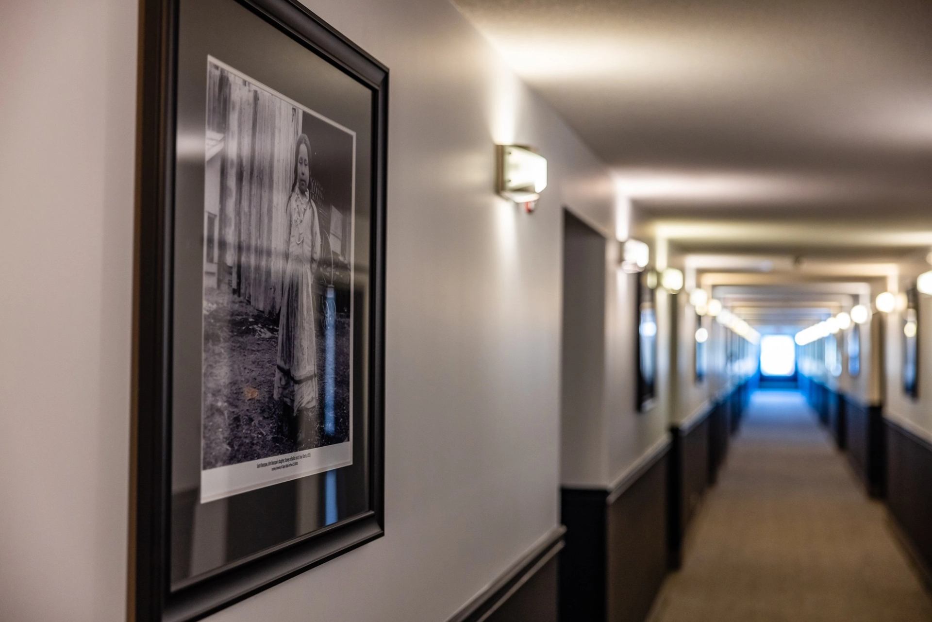 Carpeted hallway with cultural photo display.
