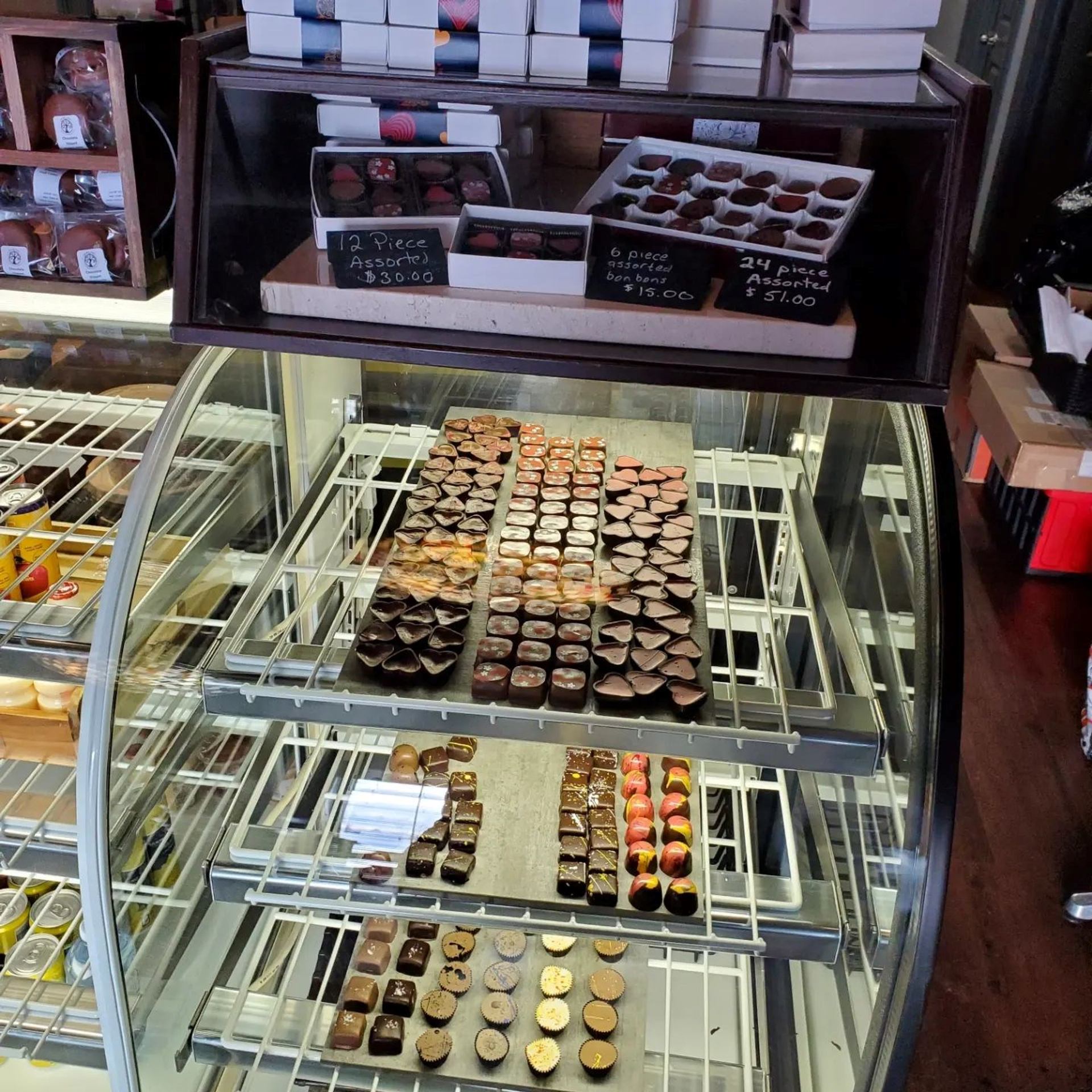 Display case filled with assorted gourmet chocolates and boxed treats.
