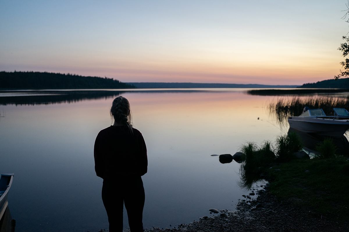 A girl looks out over Lawrence Lake at sunrise.