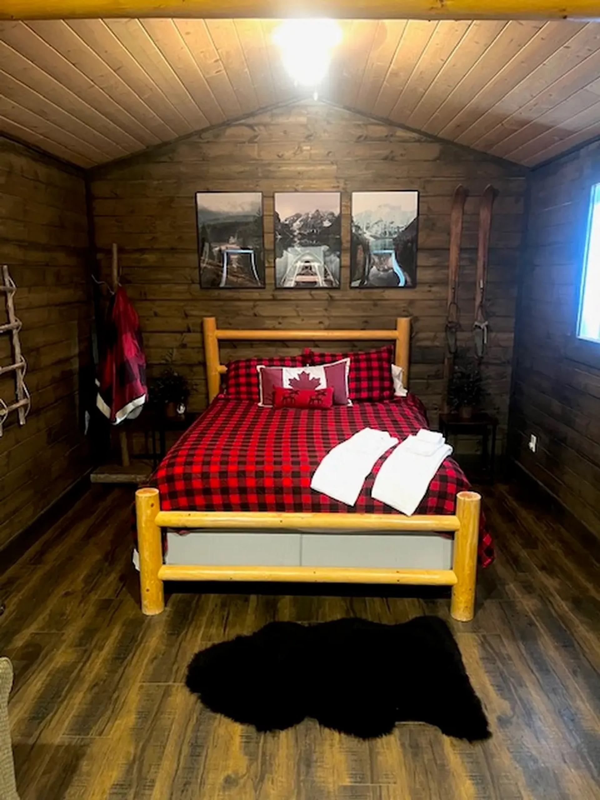 The Lumberjack Cabin with black and red plaid bedding and log bed frame