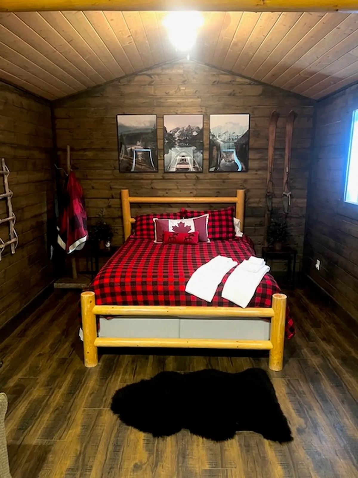 The Lumberjack Cabin with black and red plaid bedding and log bed frame