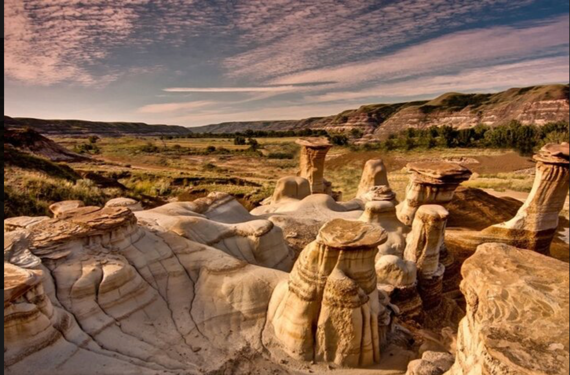 Unique hoodoo rock formations rise from the badlands, surrounded by valleys, cliffs, and open prairie.