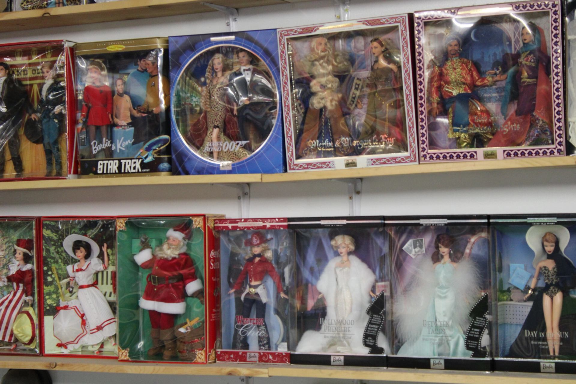 Shelves filled with boxed collectible dolls, including holiday and themed editions.