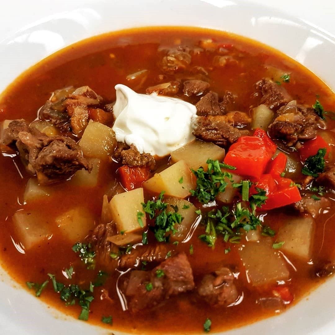 Hearty beef stew with potatoes, peppers, herbs, and a dollop of sour cream.
