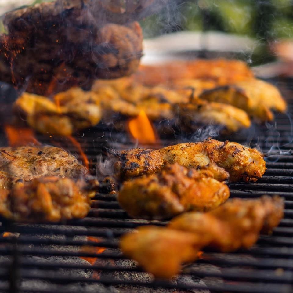Juicy chicken grilling over open flames on a barbecue.