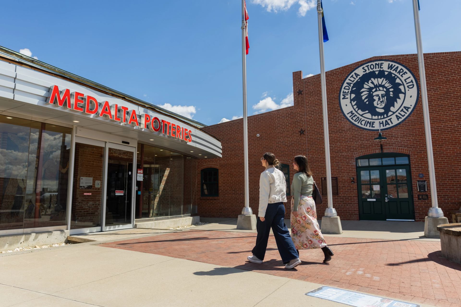 Pedestrians walk past Medalta Potteries and Medalta Stone Ware buildings.