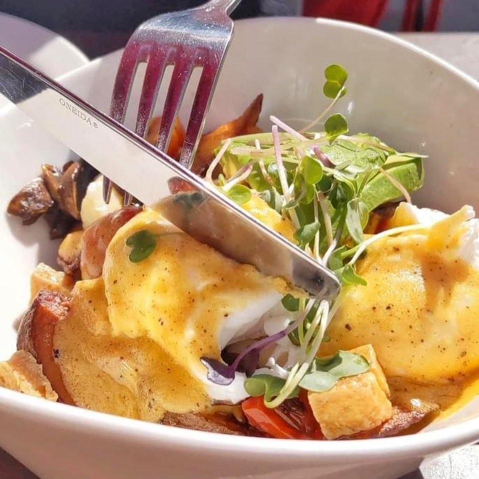 Eggs benedict with hollandaise, microgreens, and roasted potatoes at Cafe Bicyclette.