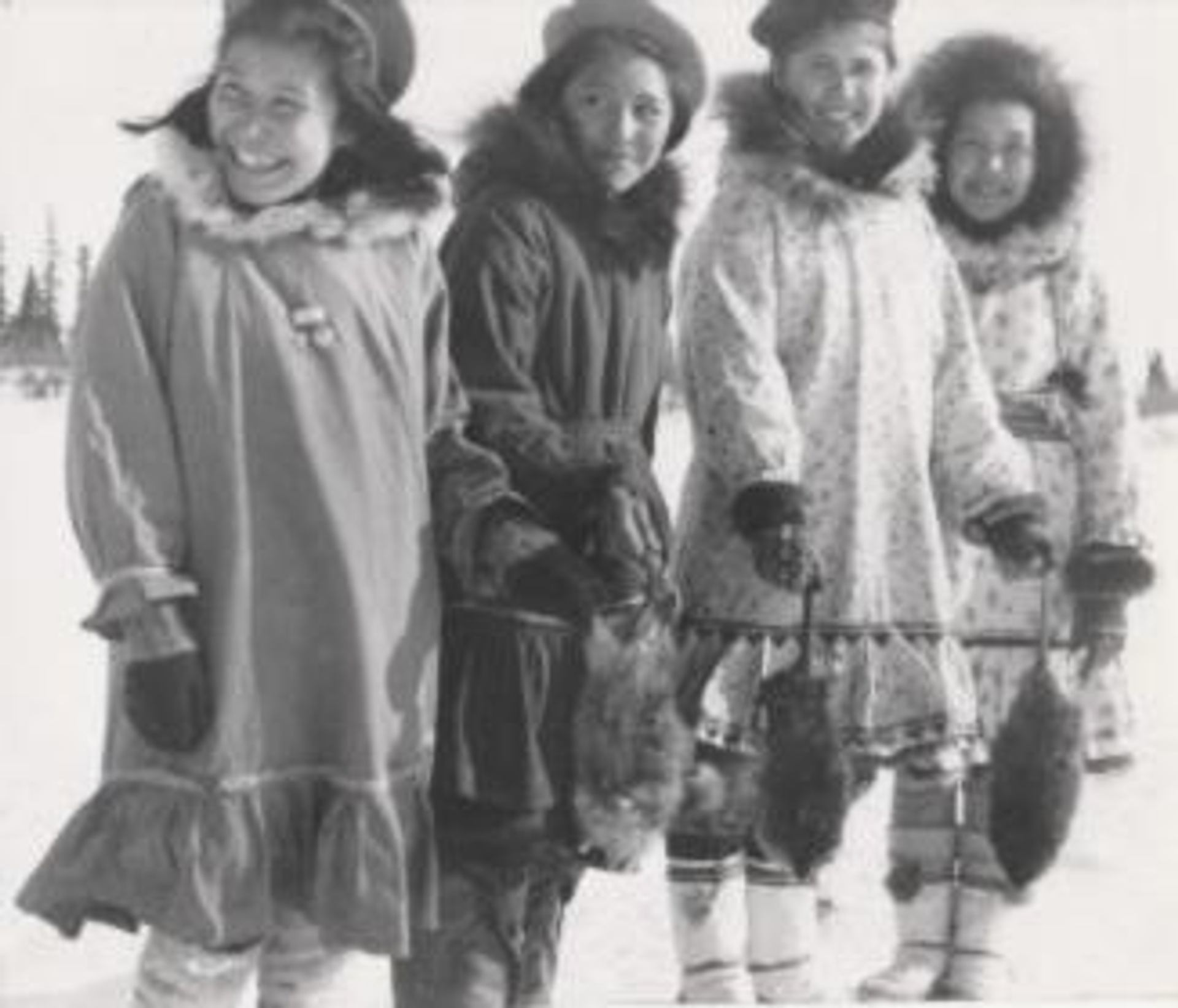A historic photo shows four Guiding members standing outdoors in winter clothing and boots.