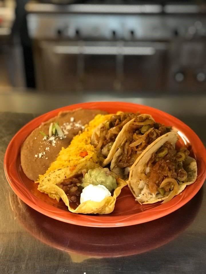 Plate of tacos, rice, beans, and sour cream at Las Palmeras.