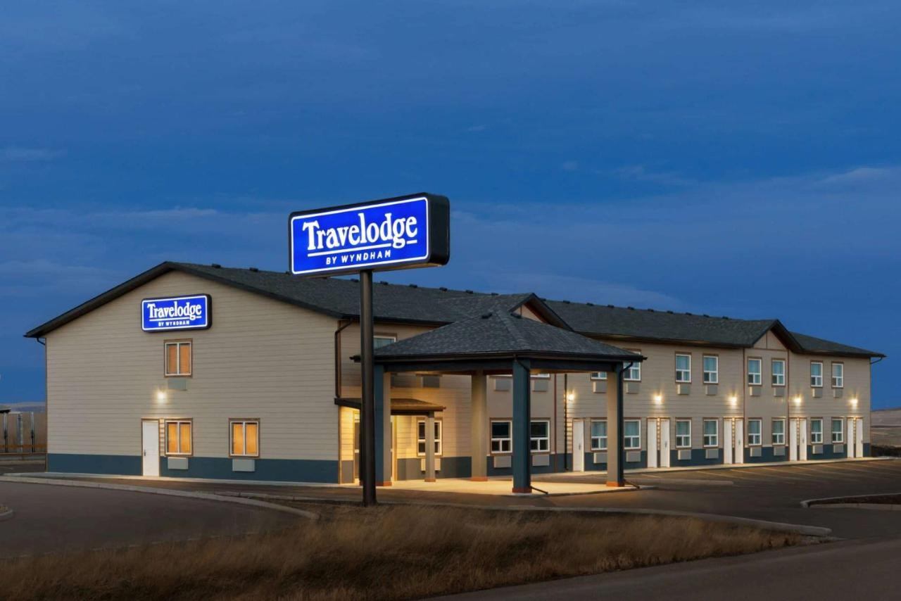 Travelodge hotel exterior at dusk with illuminated signage.